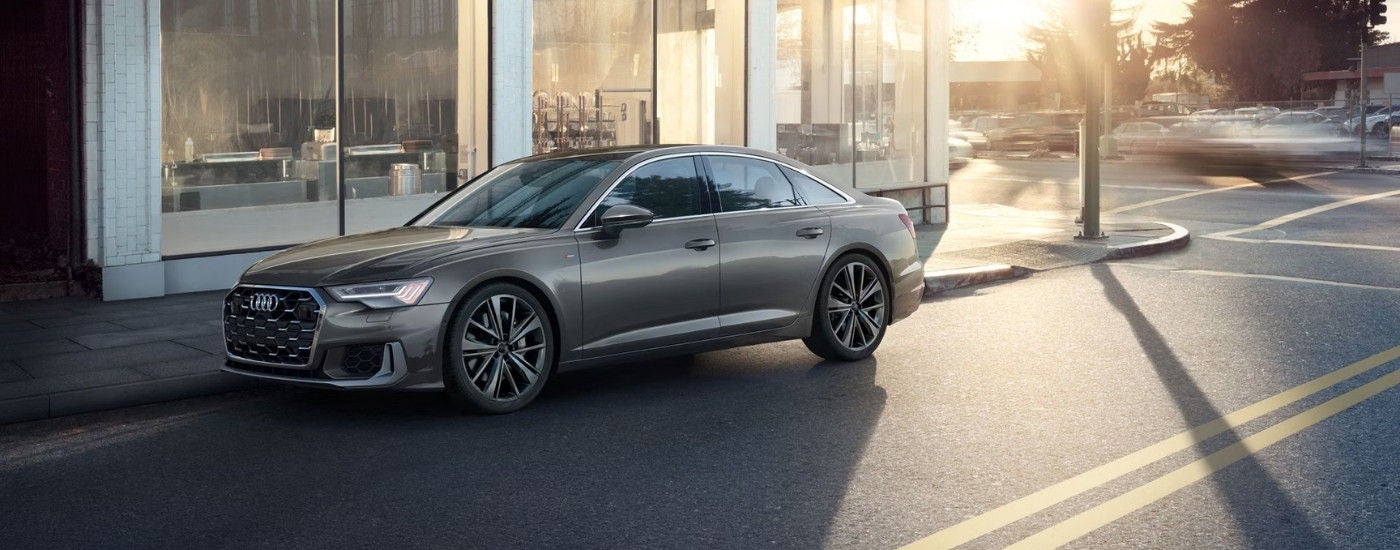 Grey 2025 Audi A6 sedan parked on the side of a street.